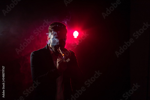 Photo of man in smoke on black and pink background.
