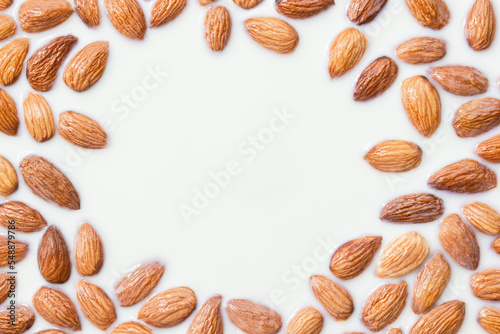 Natural almond frame in milk bath. Organic background for healthy food or skin care cosmetics. Selective focus, copy space.