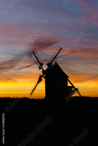 Vibrant and dramatic sky after sunset during twilight with silhouette of traditional windmill, Moulins de Trouguer, Cleden-Cap-Sizun, Brittany, France