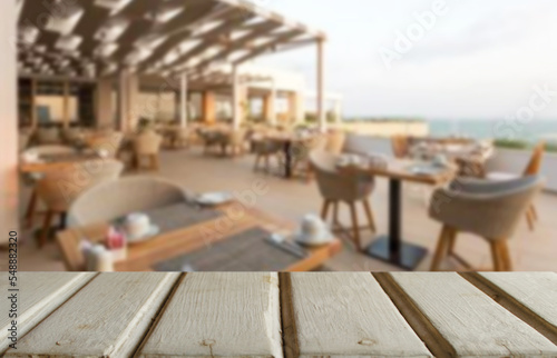 Wooden table top on blur restaurant cafe or party festival celebrate background.Place food or drink.Retro style.For montage product display or design key visual layout.View of copy space.