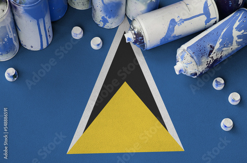 Saint Lucia flag and few used aerosol spray cans for graffiti painting. Street art culture concept photo