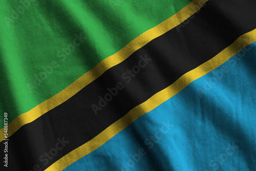 Tanzania flag with big folds waving close up under the studio light indoors. The official symbols and colors in banner photo