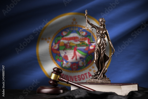 Minnesota US state flag with statue of lady justice, constitution and judge hammer on black drapery. Concept of judgement and guilt