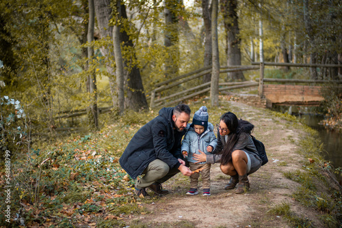 Familia paseando por un bosque otoñal con hojas caidas de los árboles