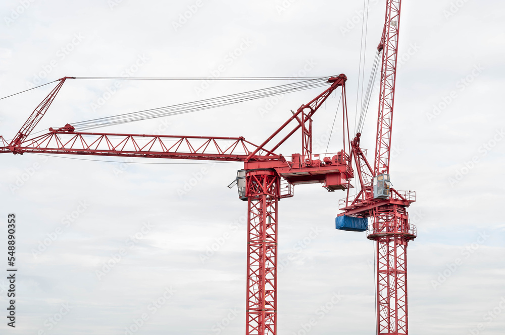 View of the construction site and red cranes for building modern residential area, construction concept for the develop city. View of the construction site and red cranes for building modern residential area, construction concept for the develop city.