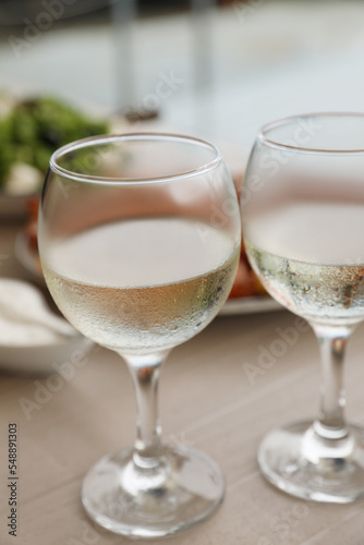 Glasses of white wine on wooden table, closeup