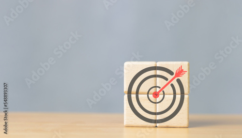 Business goals and success. Darts aim icon on wooden cube copy space