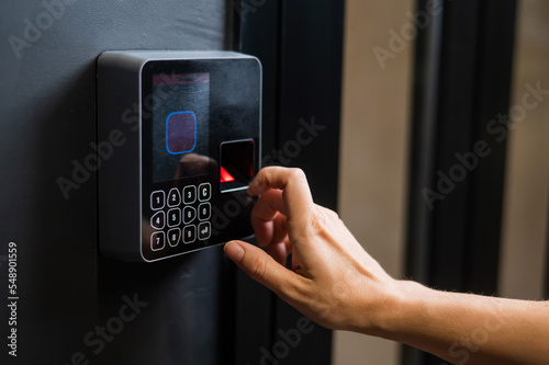 A woman opens the door with her fingerprint. Modern keyless entry lock.  photo