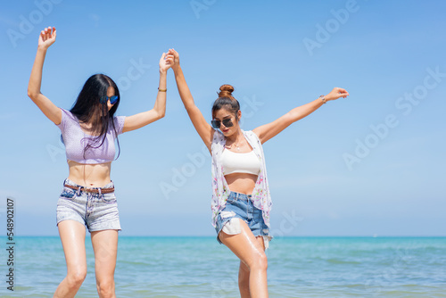 Two girlfriends hugging up and enjoying on the sea beach. A pair of girls in love cuddling on a tropical beach. romantic young lesbian couples in love and walking together on the beach.Concept of LGBT