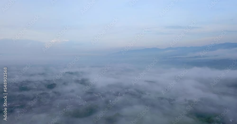 Aerial view above city in indonesia shrouded in a sea of mist Aerial view above city in indonesia shrouded in a sea of mist