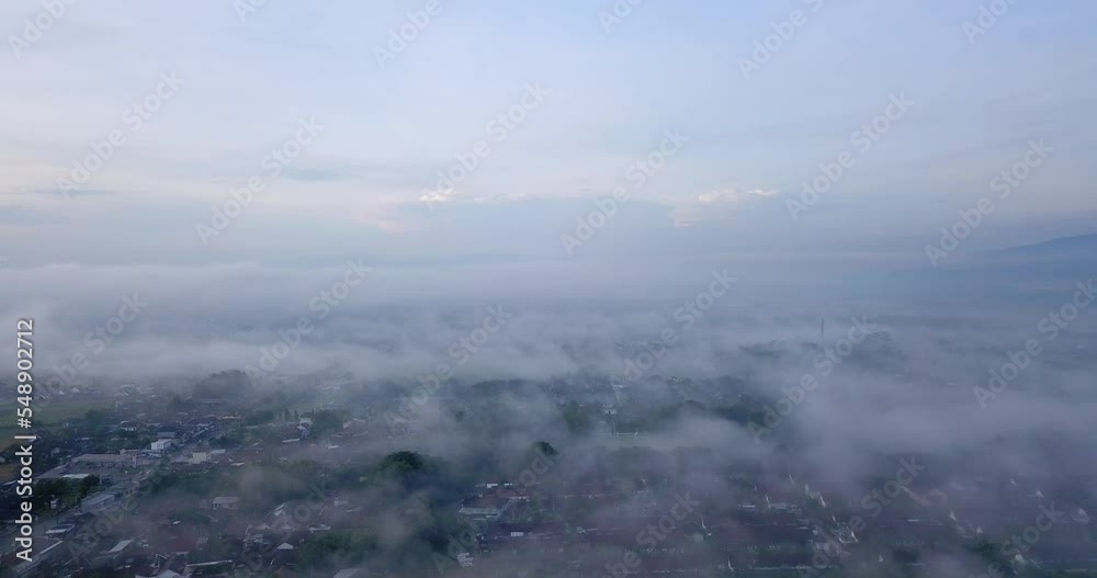 Aerial view above city that shrouded in a sea of mist Aerial view above city that shrouded in a sea of mist
