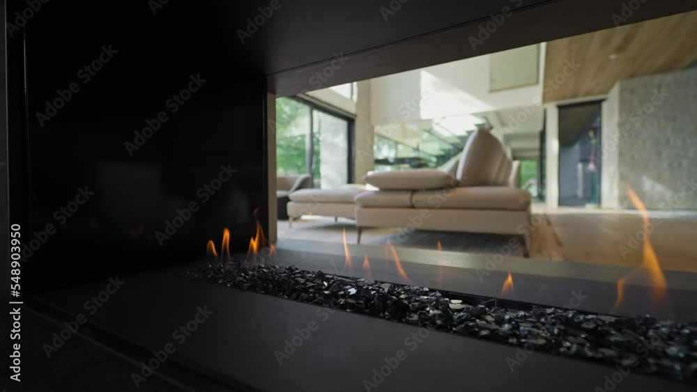3-sided Modern Gas Fireplace Open on Three Sides in Luxury House Interior - side dolly in slow motion