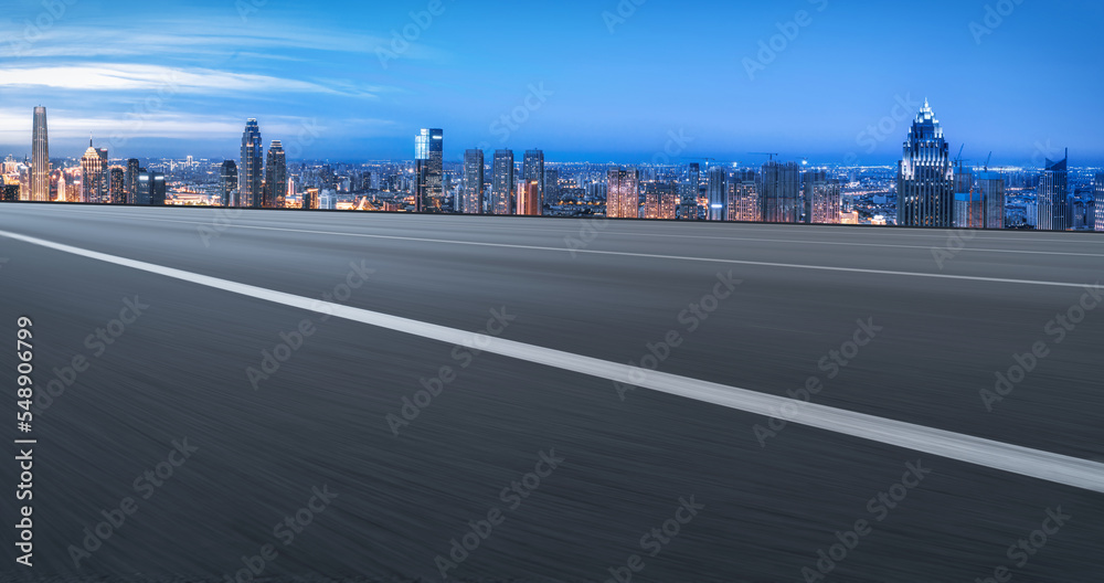 Naklejka premium Background of asphalt pavement and urban architectural landscape skyline