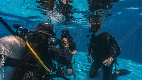 Valokuva diving instructor teaches students to scuba dive in swimming pool