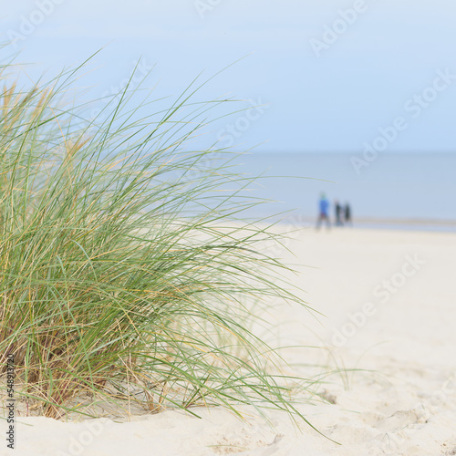 Strand an der K  ste von Swinoujscie an der polnischen Ostseek  ste. Im Hintergrund unscharfe Spazierg  nger.