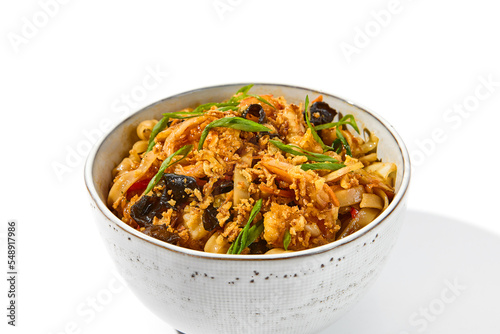 Asian fried noodles with shiitake mushrooms and vegetables isolated on white background Chinese fried noodles in vegetarian style in ceramic bowl. Stir-fry udon with vegetables and mushrooms