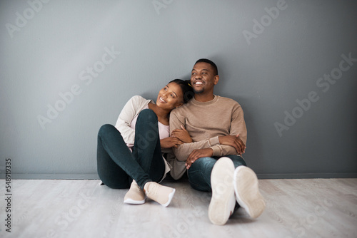 Apartment, love and couple on floor with wall background relax, rest and bond after moving in new home together. Real estate, dating and young black couple in living room thinking of house design