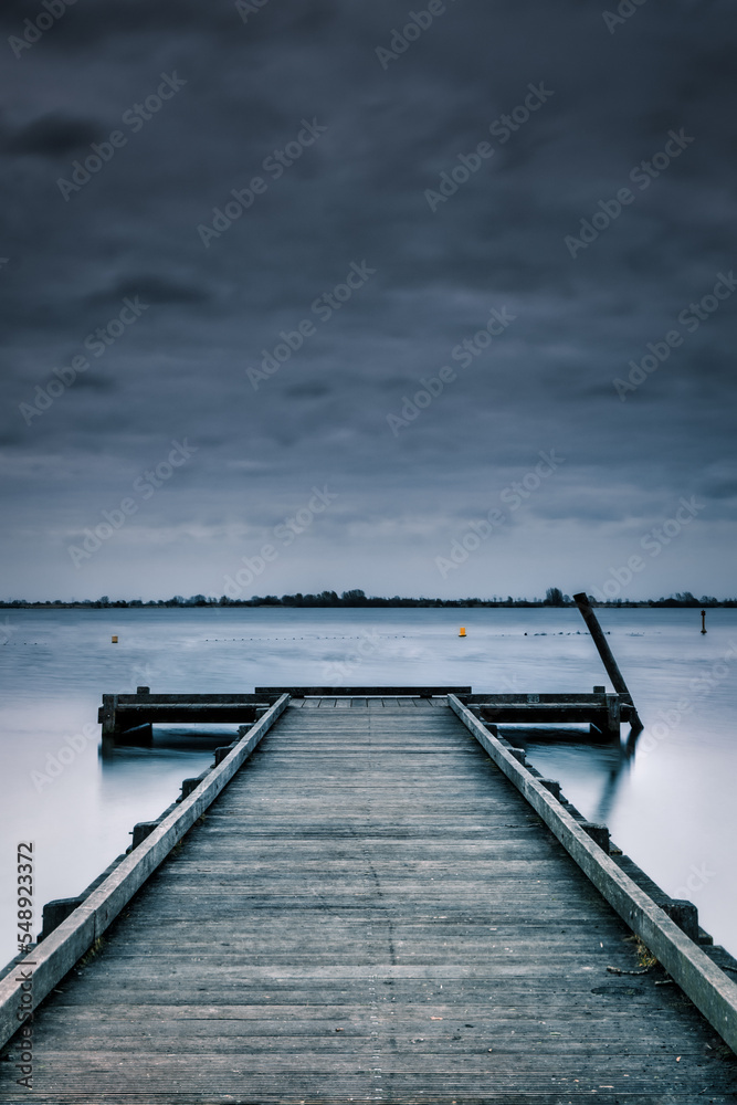 Fototapeta premium wooden pier in a lake with clouds