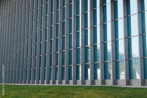 Close-up building exterior geometric wall with blue windows. Side view  perspective