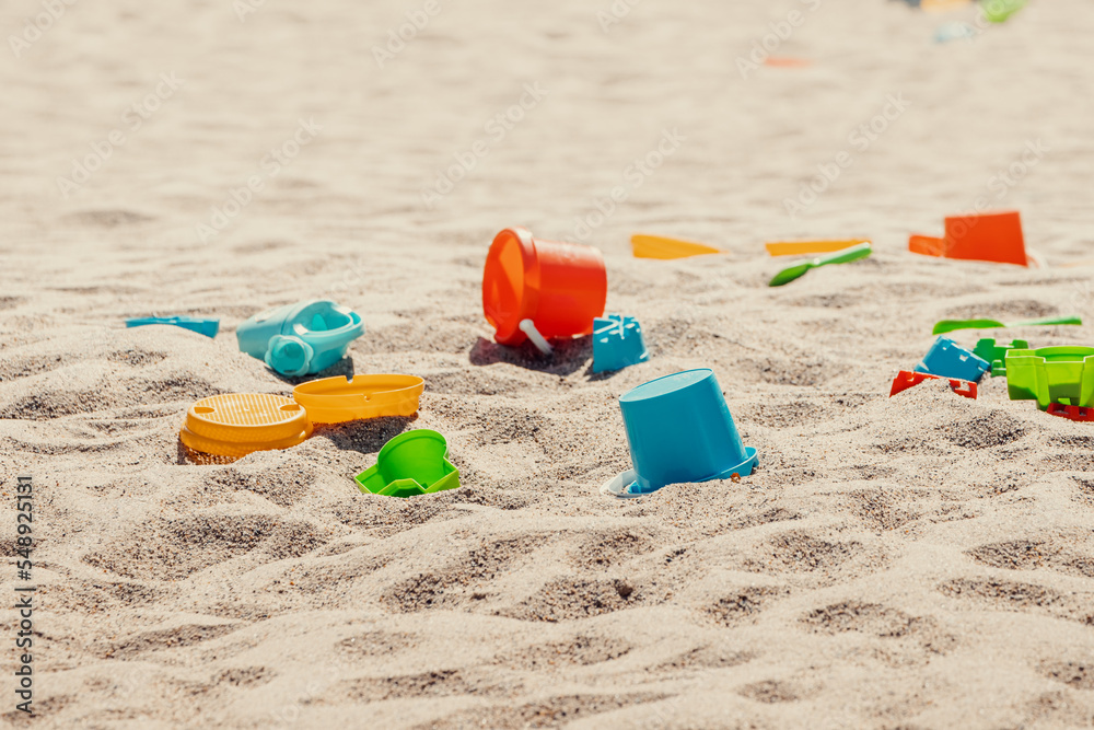 Toys are scattered in a large children's sandbox. Childhood and leisure of kids Toys are scattered in a large children's sandbox. Childhood and leisure of kids
