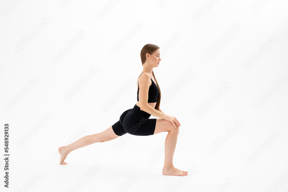 Beautiful brunette fitness woman doing yoga on a white background
