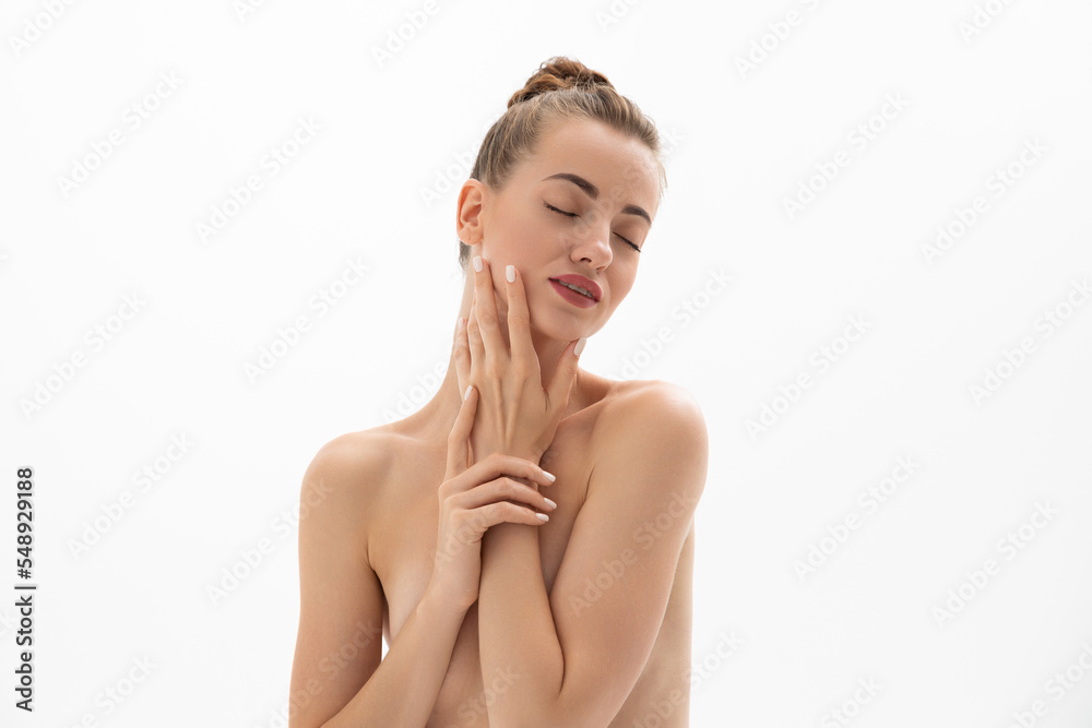 Obraz premium Beautiful young woman with clean skin touches her face. Cosmetology, treatment, health and spa.