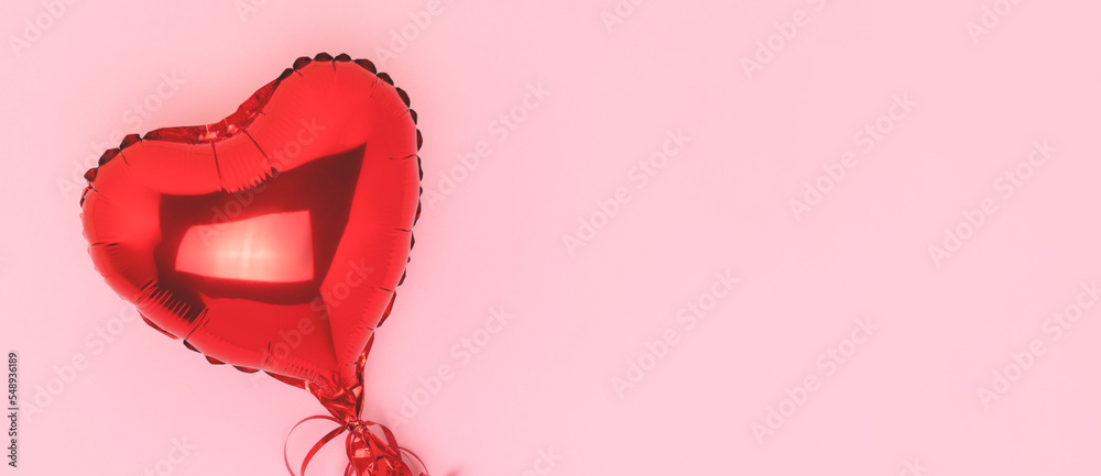 Banner with red inflatable foil balloon in a heart shape. Minimal composition on a pink background with place for text. Banner with red inflatable foil balloon in a heart shape. Minimal composition on a pink background with place for text.