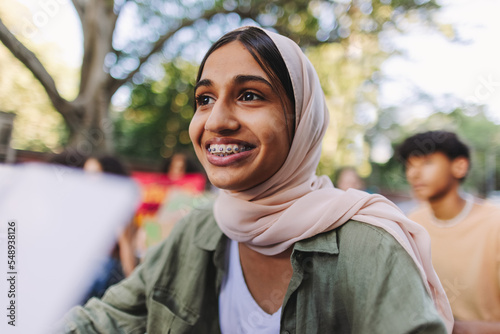 Muslim girl smiling happily at a climate protest photo