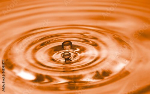 Water droplets on water surface created wave and ripple textured background. 