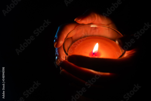 Close up of woman hand lighting candles in the dark night at home