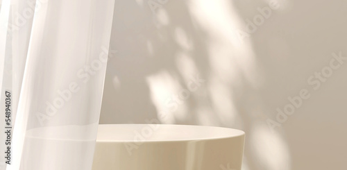 Modern and luxury cream colored round glossy pedestal podium in dappled sunlight from window with white blowing sheer curtain in white wall background for product display