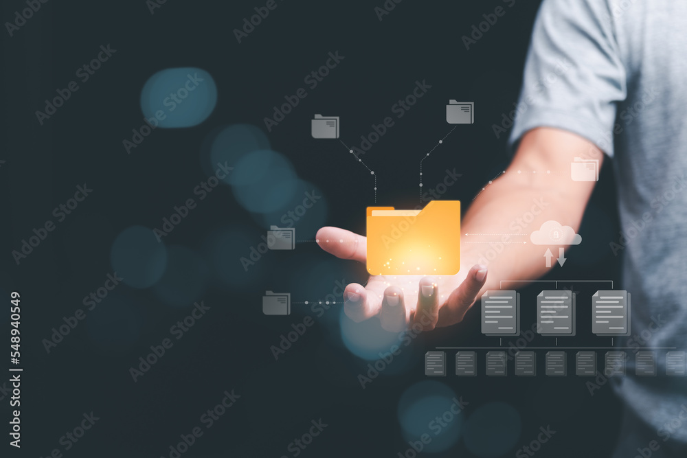 A businessman manages his organization's document database through the cloud. cyberspace technology concept and large important documents, file management and paperless online storage A businessman manages his organization's document database through the cloud. cyberspace technology concept and large important documents, file management and paperless online storage