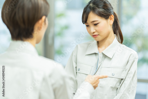 叱責する作業着を着た日本人女性