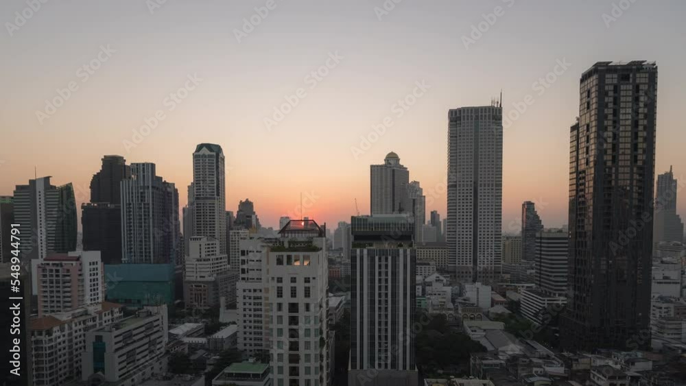 Zoom out day to night time lapse of Bangkok's downtown area skyline of high rise buildings with beautiful colored sunset sky Zoom out day to night time lapse of Bangkok's downtown area skyline of high rise buildings with beautiful colored sunset sky