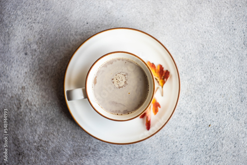 Overhead view of a cup of coffee with milk and autumnal leaf decorations photo