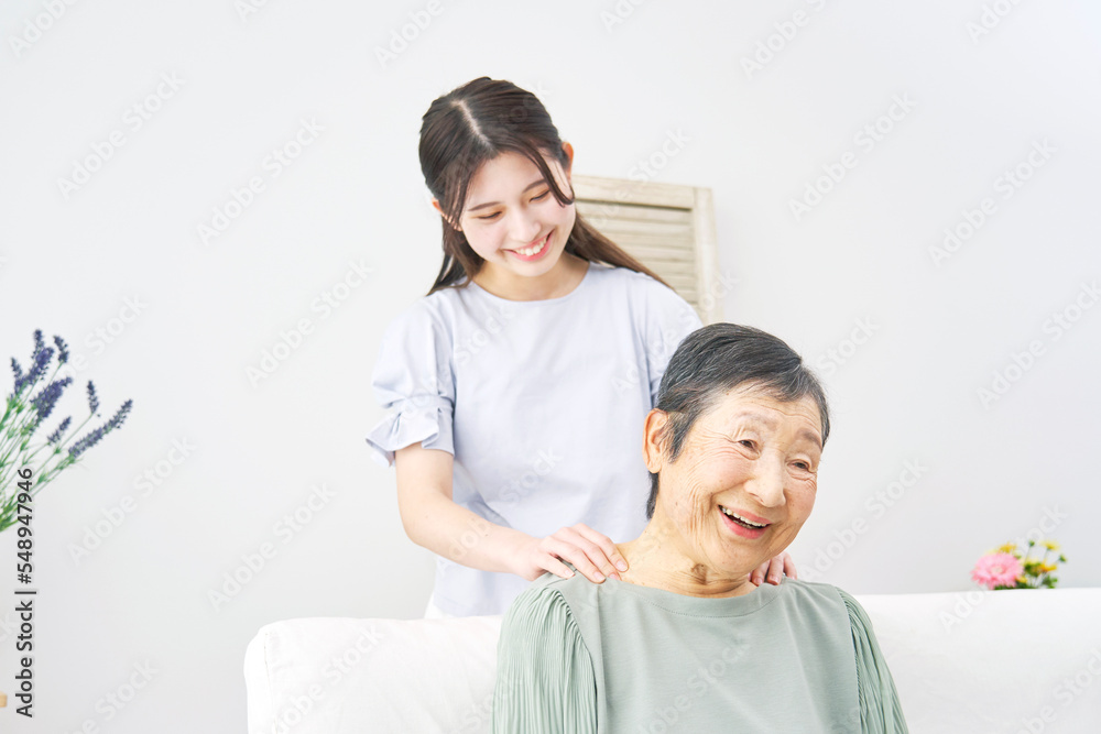 Fototapeta premium 祖母の肩揉みをする孫
