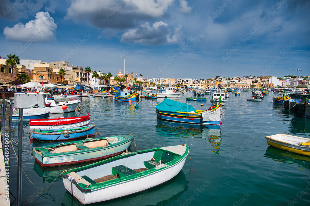 View of Traditional fishing boats Luzzu in the Ancient Mediterranean Village of fishermen in Marsaxlokk, Malta