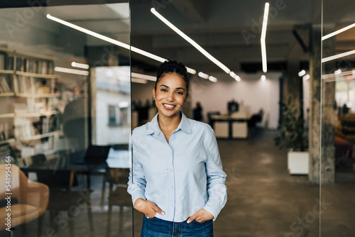 Smiling African businesswoman standing at the office, posing for the camera.