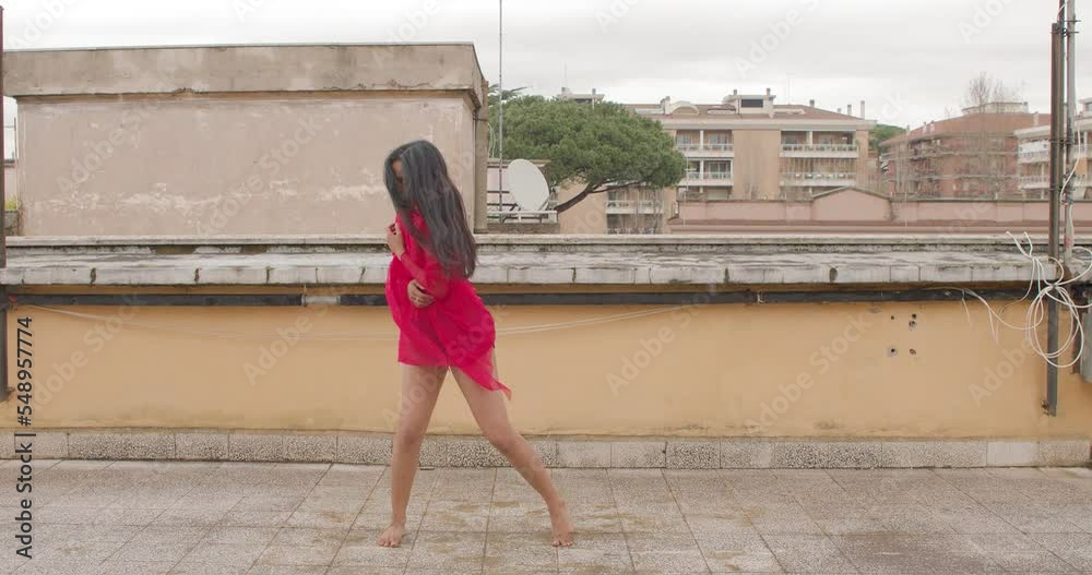 young indian woman performing a classical dance choreography on the roof