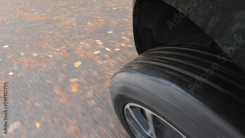 Close up view of rolling left front wheel of car while reversing out of driveway