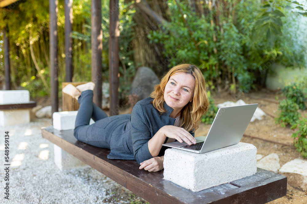 A beautiful freelancer woman works at the park using a computer. A beautiful freelancer woman works at the park using a computer.