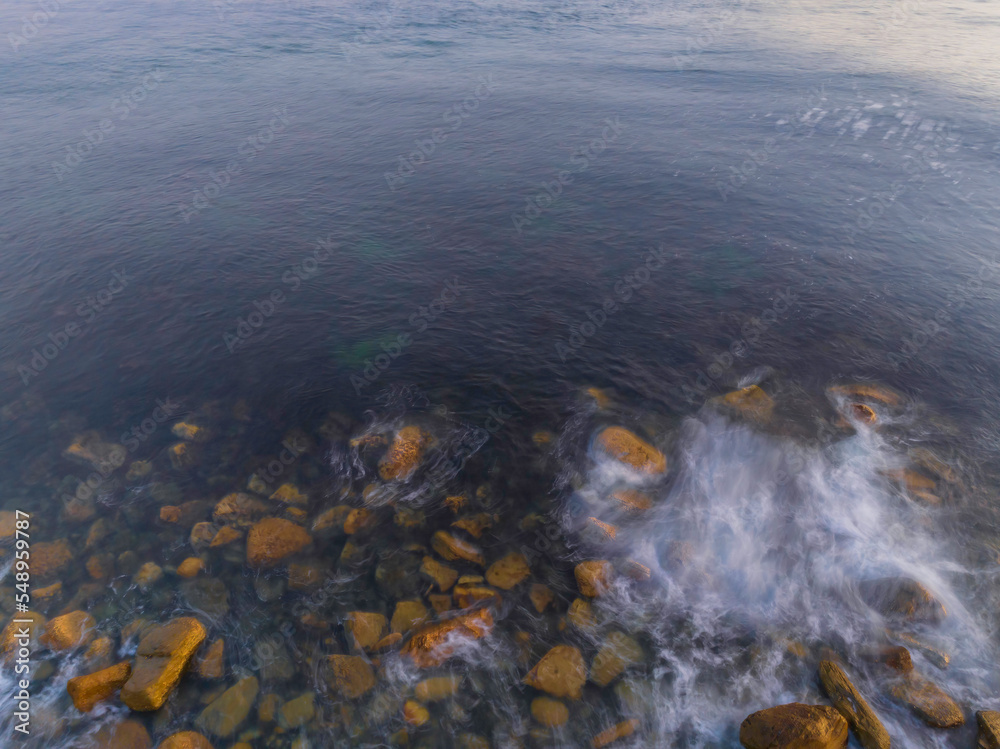 Top down sunrise over the ocean with rocks