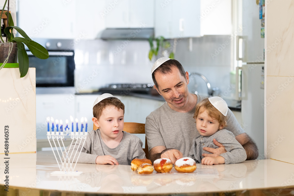 Father and sons with menorah celebrate hanukkah - Jewish religious holiday Father and sons with menorah celebrate hanukkah - Jewish religious holiday
