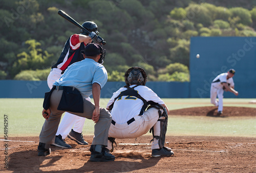 Baseball players in action on the stadium, baseball batter waiting to strike the ball. Baseball pitcher following through to pitch to right handed batter