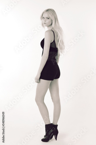 Fashion, beauty and portrait with a woman in studio on a mockup space white studio background. High heels, monochrom and style with a young female model posing for a contemporary or elegant style © FD/peopleimages.com