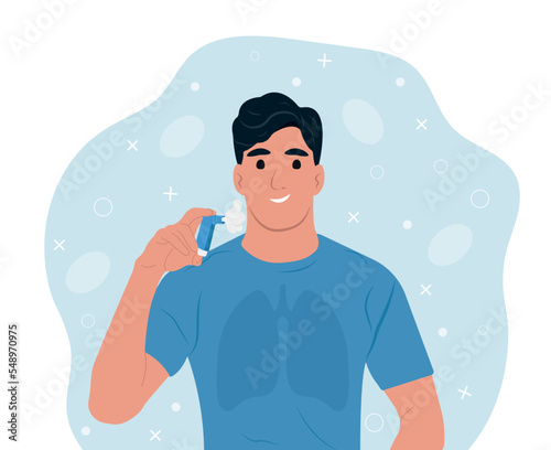 Young smiling man using an asthma inhaler World Asthma Day.Bronchial Asthma. Allergy, asthmatic. Inhalation drug. Bronchial asthma.
