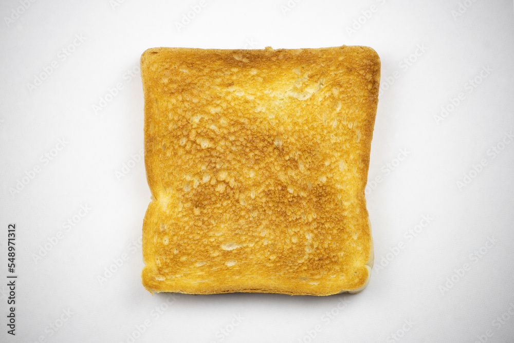 Toasted slice of bread on a white background. Cooked in a toaster. Toasted slice of bread on a white background. Cooked in a toaster.