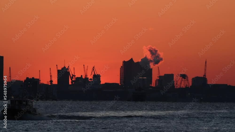 Sun rises behind city skyline, telephoto shot, backlight scene, colorful sky, boat on elbe river, warm, summer, heat,