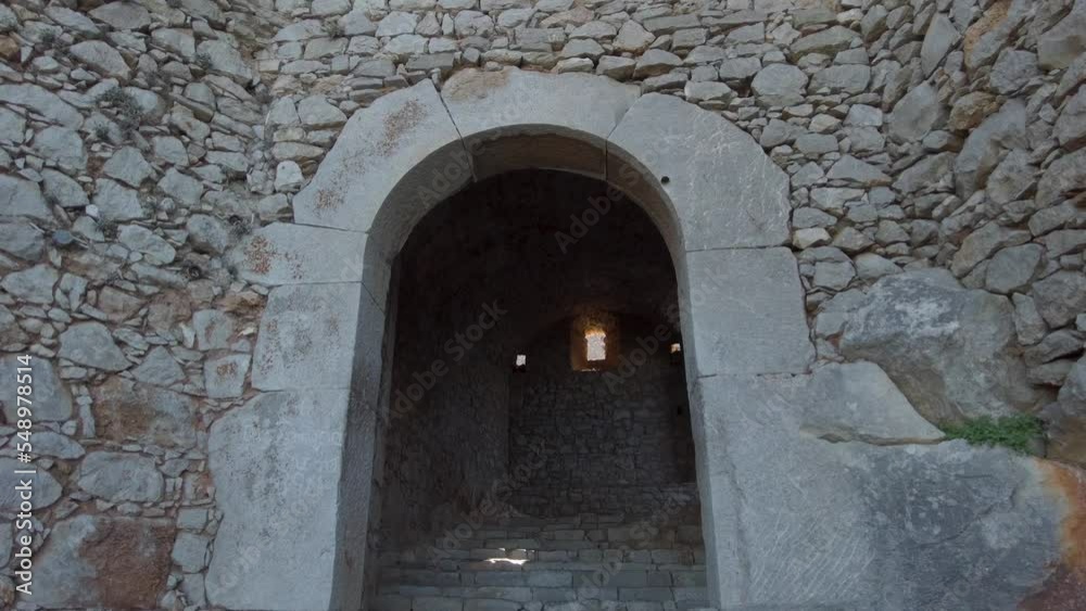 Tilt down at an old bell tower with entrance door below in greece on a sunny day Tilt down at an old bell tower with entrance door below in greece on a sunny day