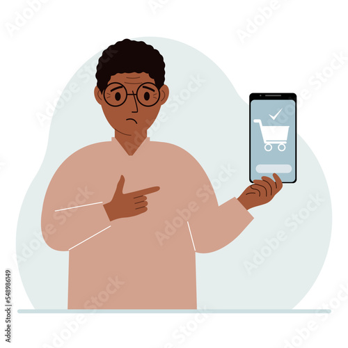 A man holds a mobile phone in his hand with an application for online shopping. The phone has a shopping cart.